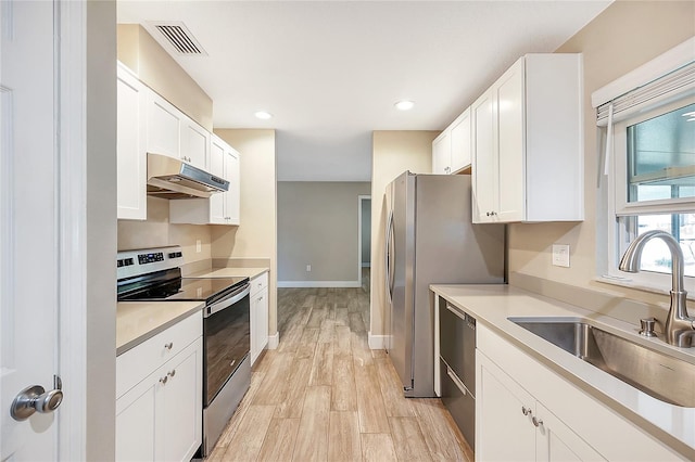 kitchen featuring visible vents, under cabinet range hood, a sink, white cabinetry, and appliances with stainless steel finishes