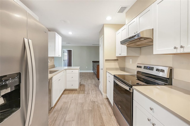 kitchen with visible vents, light wood finished floors, under cabinet range hood, appliances with stainless steel finishes, and light countertops