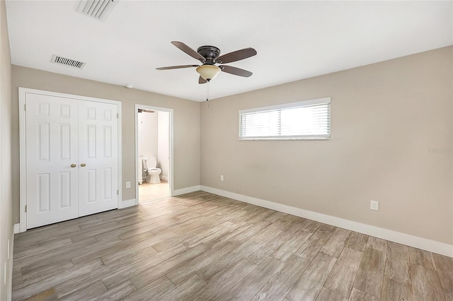 unfurnished bedroom with a closet, baseboards, visible vents, and light wood finished floors