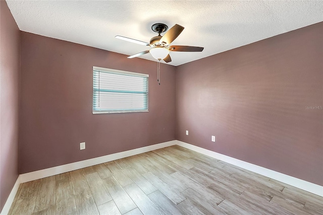 unfurnished room featuring a textured ceiling, baseboards, light wood finished floors, and ceiling fan