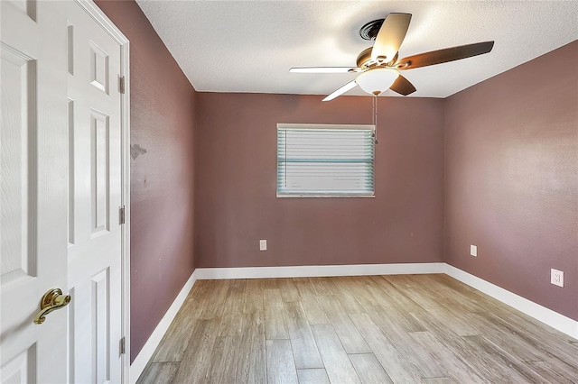 empty room featuring a textured ceiling, baseboards, ceiling fan, and wood finished floors