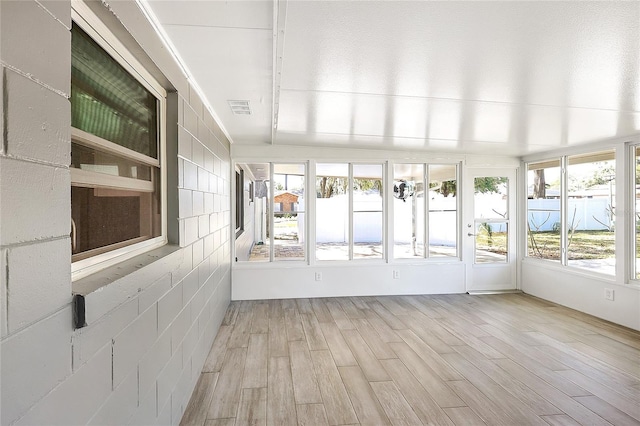 unfurnished sunroom featuring visible vents and a healthy amount of sunlight