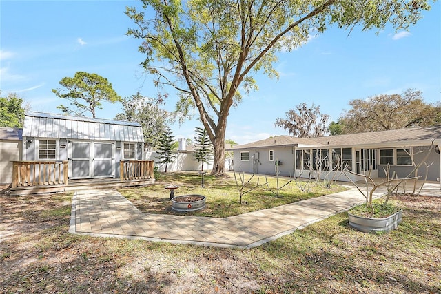 view of yard featuring an outdoor structure and a sunroom