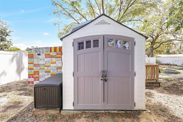 view of shed featuring fence