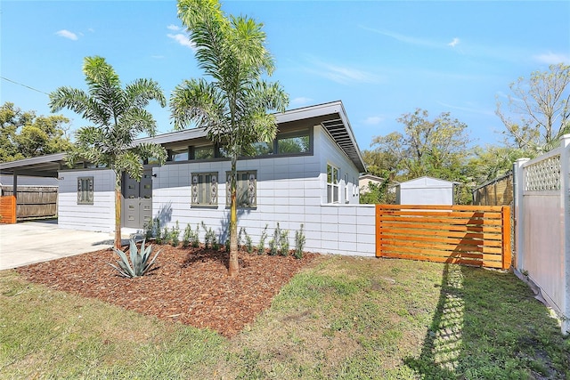 view of front of home featuring driveway, a front lawn, and fence