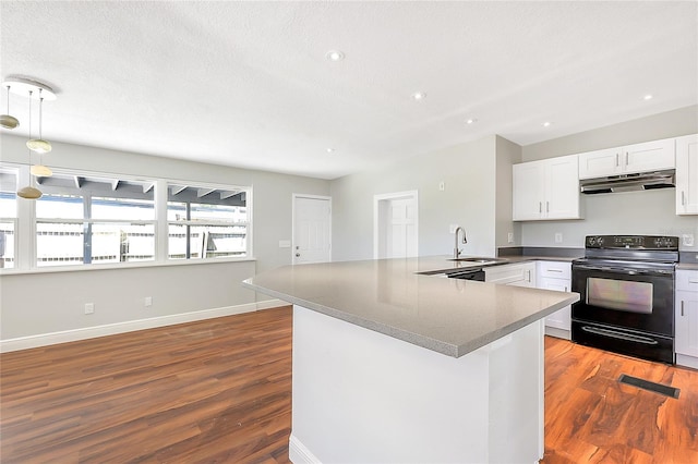 kitchen with black range with electric cooktop, under cabinet range hood, a peninsula, wood finished floors, and white cabinetry