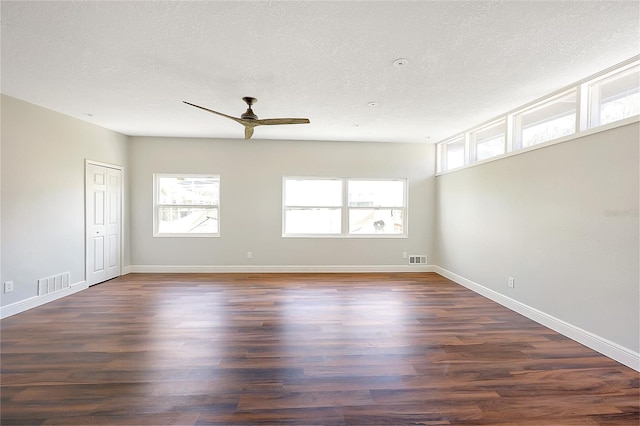 spare room with visible vents, dark wood-style flooring, and a textured ceiling