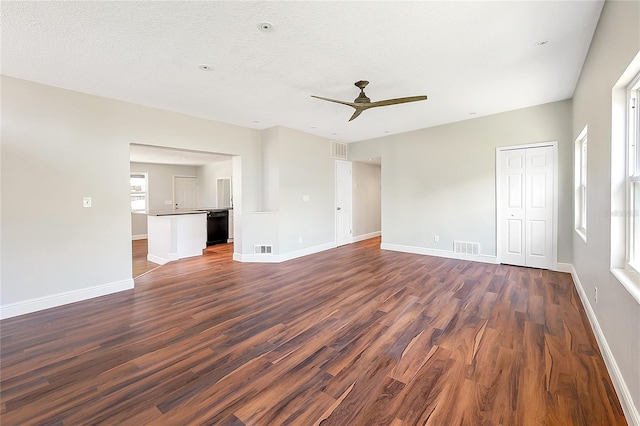 unfurnished living room with visible vents, baseboards, and dark wood-style floors