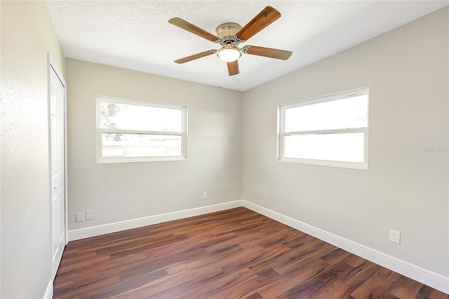 unfurnished room featuring dark wood finished floors, ceiling fan, baseboards, and a textured ceiling