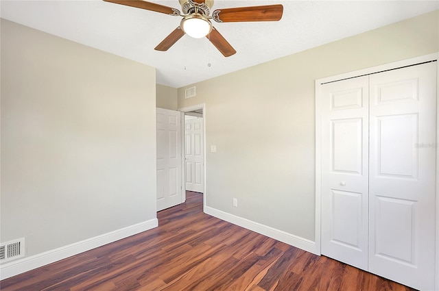 unfurnished bedroom with visible vents, a ceiling fan, wood finished floors, a closet, and baseboards