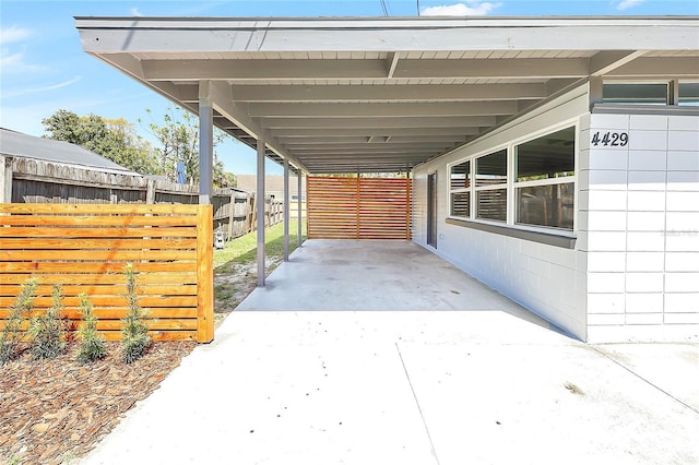 view of patio featuring a carport and fence