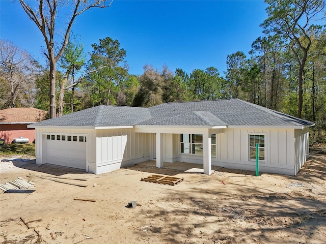 view of front of home with a garage, board and batten siding, and a shingled roof