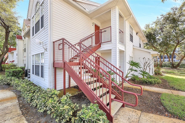 view of home's exterior featuring stairway and central AC unit