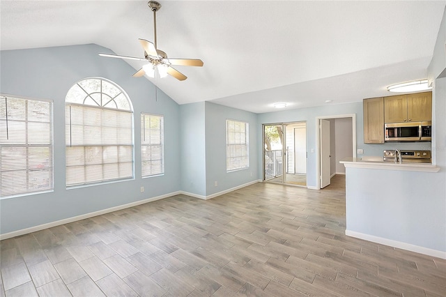 unfurnished living room featuring lofted ceiling, baseboards, light wood-type flooring, and ceiling fan