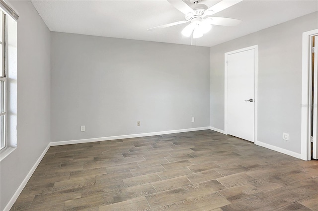 unfurnished room with ceiling fan, baseboards, and wood finished floors