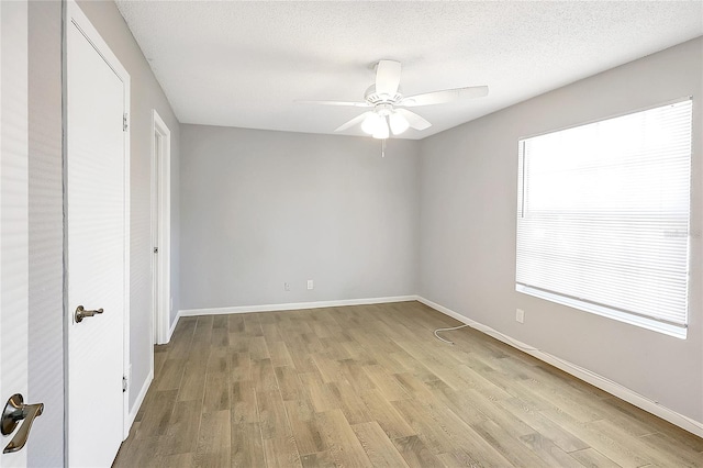 unfurnished bedroom featuring baseboards, a textured ceiling, a ceiling fan, and light wood finished floors