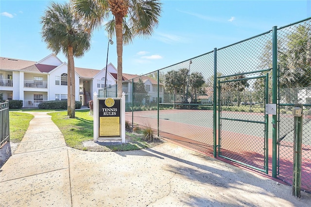 view of sport court with a residential view, fence, and a gate