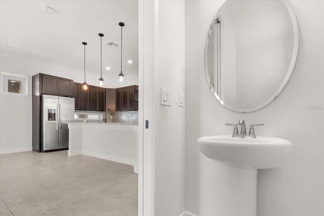 bathroom with tasteful backsplash, visible vents, and a sink