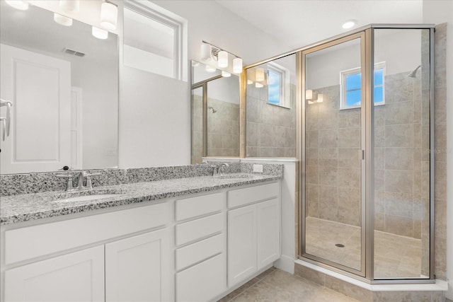 bathroom featuring a sink, visible vents, double vanity, and a shower stall