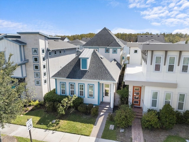 view of front of house featuring a residential view and a shingled roof