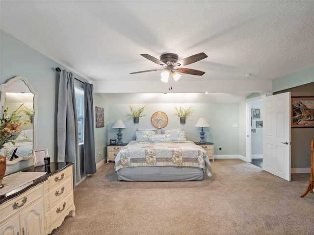 bedroom featuring baseboards, light carpet, a textured ceiling, and a ceiling fan