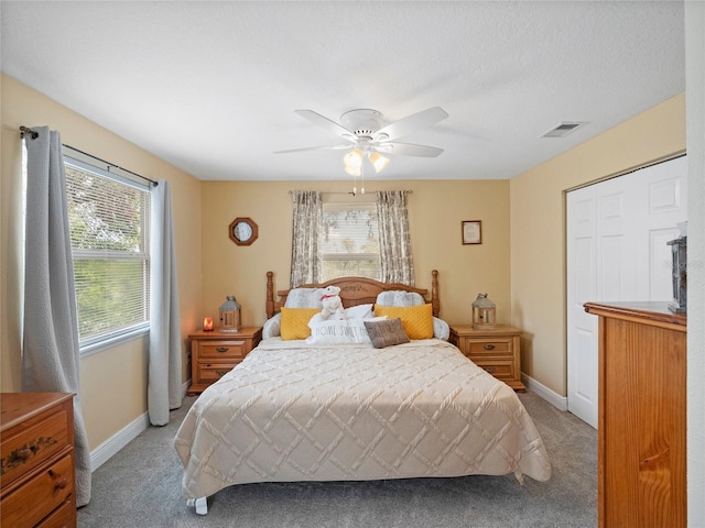 bedroom featuring a ceiling fan, baseboards, visible vents, and light carpet