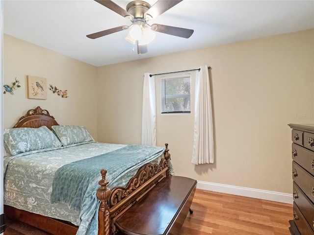 bedroom with a ceiling fan, baseboards, and light wood finished floors