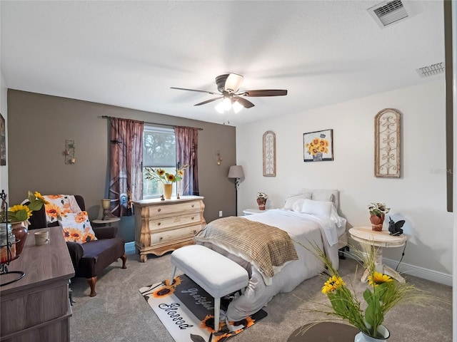 bedroom with visible vents, baseboards, light colored carpet, and ceiling fan