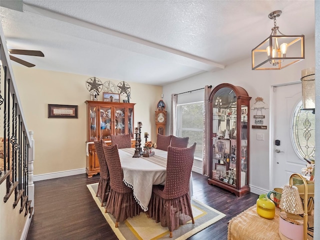 dining room with baseboards, beamed ceiling, ceiling fan with notable chandelier, a textured ceiling, and dark wood-style flooring