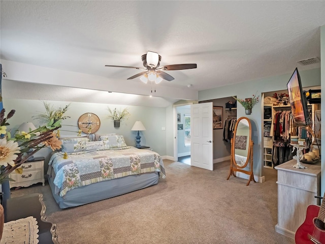 carpeted bedroom with a ceiling fan, visible vents, baseboards, multiple closets, and a textured ceiling