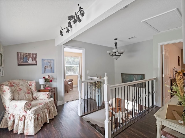 interior space with wood finished floors, visible vents, lofted ceiling, and an upstairs landing