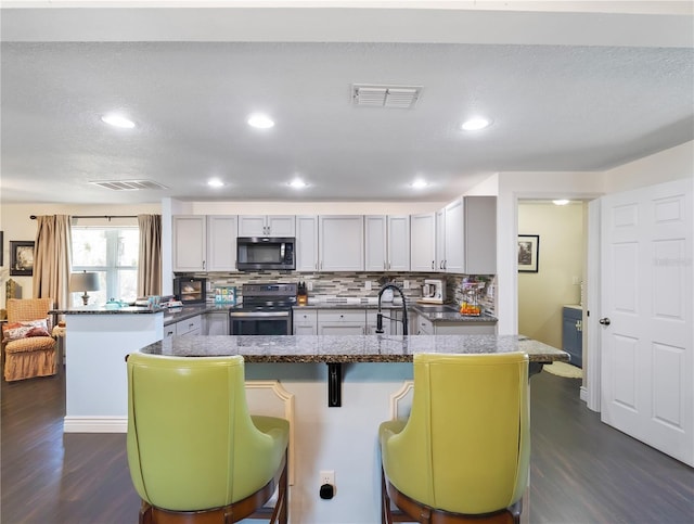 500 Forest Lake Dr, Altamonte Springs, FL 32714 - kitchen with stainless steel electric stove, a peninsula, dark wood-style flooring, tasteful backsplash, and dark countertops