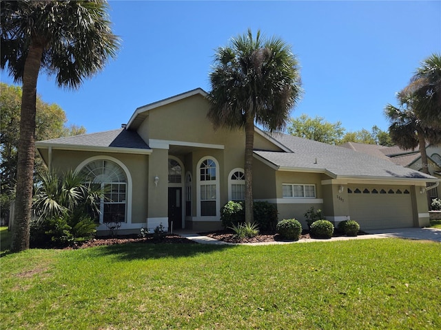 single story home featuring a garage, stucco siding, and a front lawn