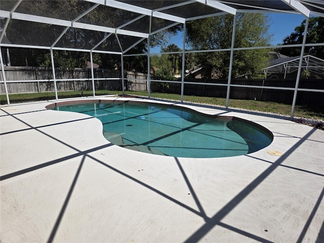 view of pool featuring glass enclosure, a patio, a fenced backyard, and a fenced in pool