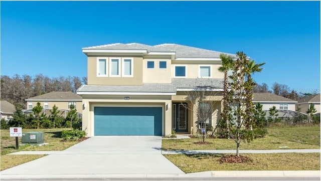 view of front of home featuring concrete driveway, a garage, a front yard, and stucco siding