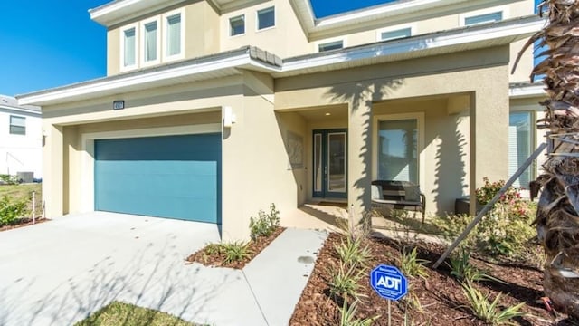 view of front of home with stucco siding, driveway, and an attached garage