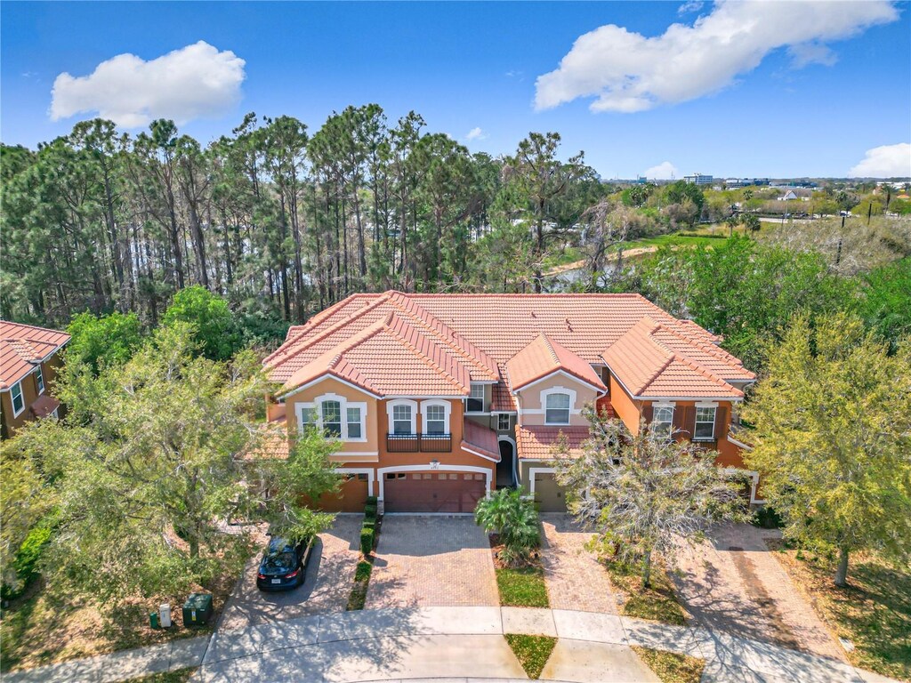 4952 Matteo Trl, Orlando, FL 32839 - view of front of property featuring decorative driveway, a tile roof, an attached garage, and stucco siding