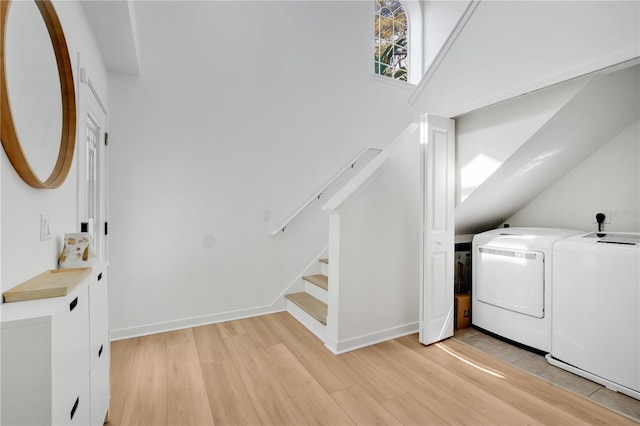 washroom featuring baseboards, separate washer and dryer, laundry area, and light wood finished floors