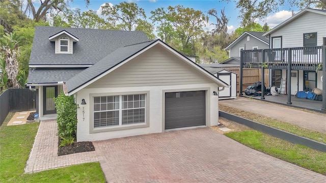 garage featuring decorative driveway and fence