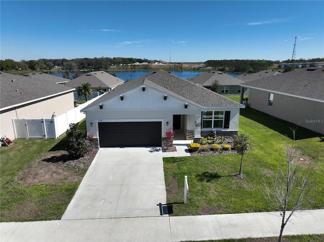 view of front of home with a front lawn, a gate, fence, concrete driveway, and an attached garage