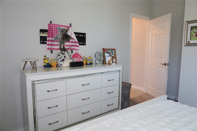 bedroom featuring light tile patterned flooring and baseboards