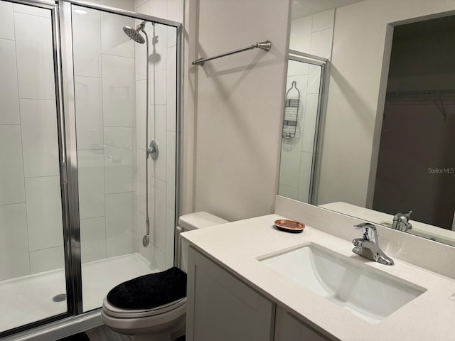 full bathroom featuring a shower stall, toilet, and vanity