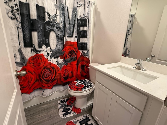 full bathroom featuring toilet, vanity, and wood finished floors