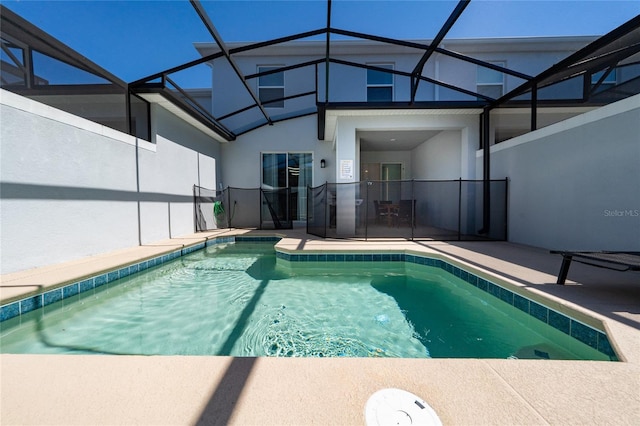 pool featuring glass enclosure and a patio area