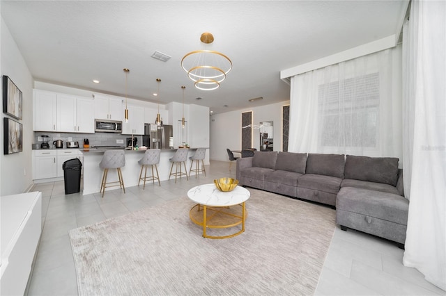 living area featuring light tile patterned floors, visible vents, and recessed lighting