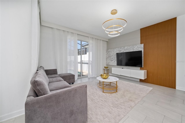 living room featuring baseboards and an inviting chandelier