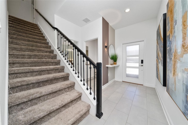 entryway with tile patterned floors, visible vents, recessed lighting, stairway, and baseboards