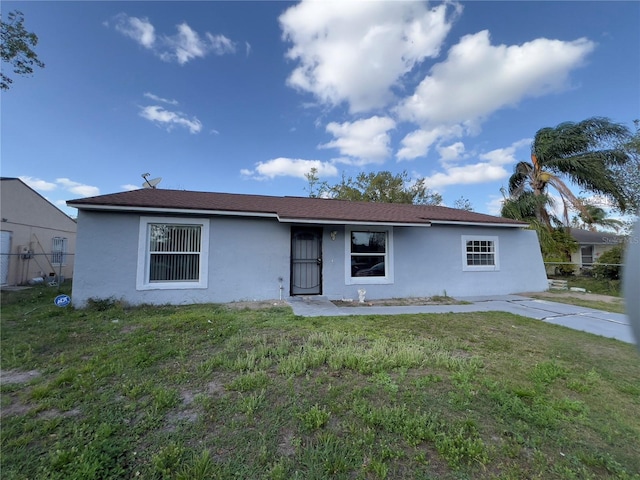 view of front of house featuring stucco siding and a front lawn