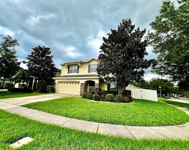 traditional-style home featuring fence, a front yard, stucco siding, a garage, and driveway