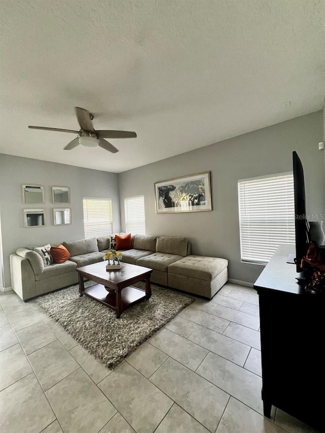 living room with light tile patterned floors, a textured ceiling, and a ceiling fan